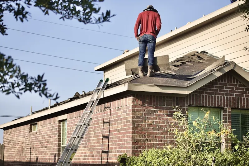 Professional roofer working on a residential roof in Riverdale Hills
